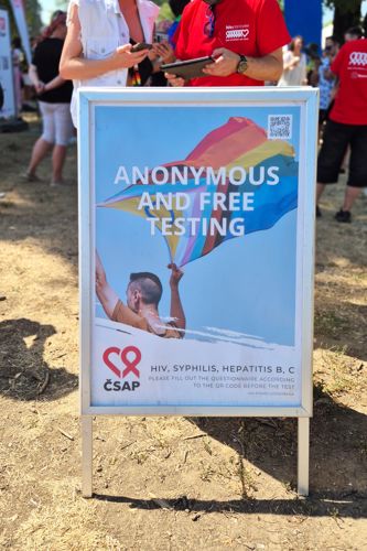 Informační tabule České společnosti AIDS pomoc upozorňující na bezplatné a anonymní testování na HIV, syfilis a hepatitidu B a C během Prague Pride 2026.