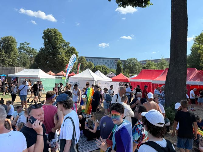 Návštěvníci Prague Pride 2026 v Pride Parku, v pozadí stánek BioVendor Group.